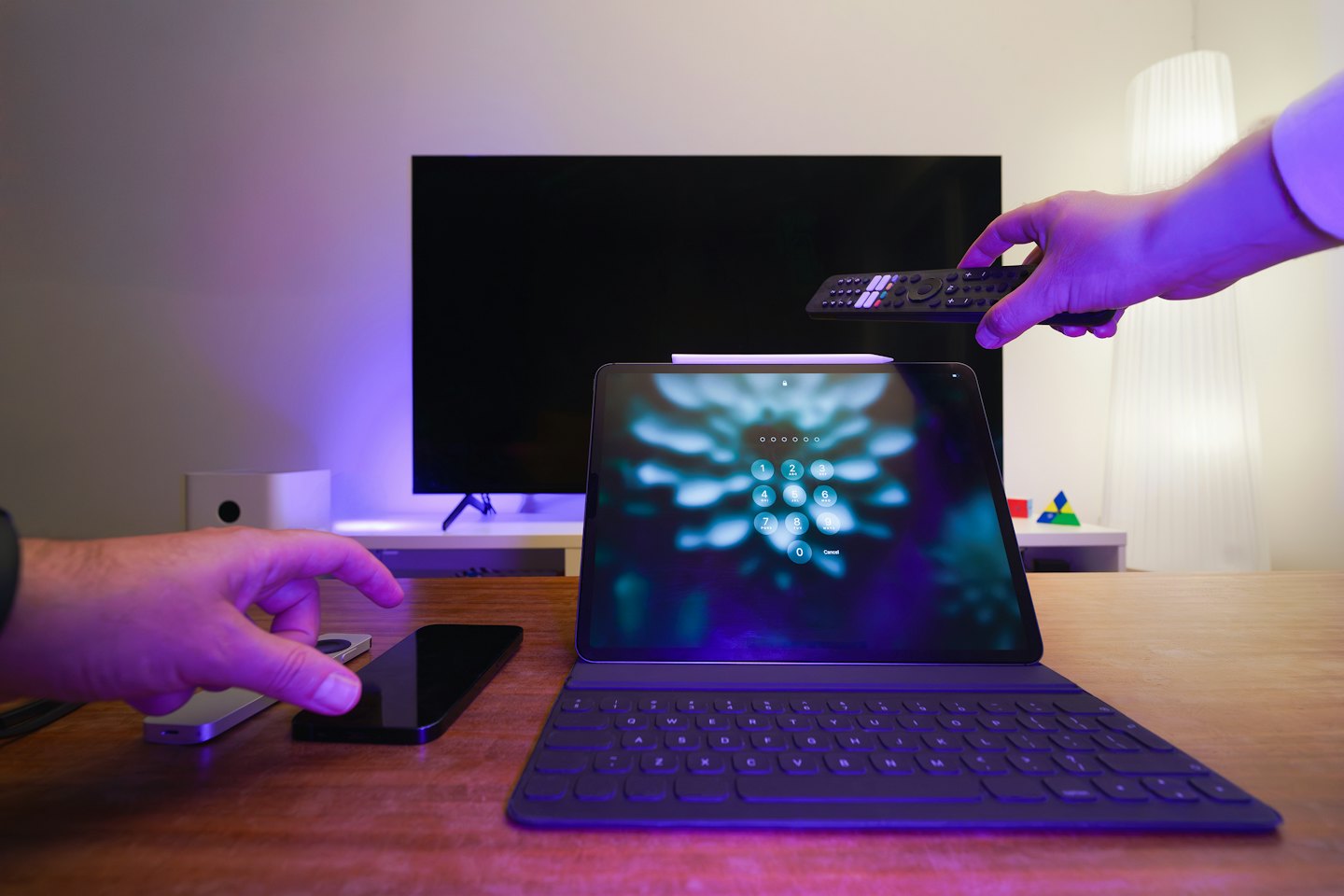 Mains interagissant avec la technologie de maison intelligente sur un bureau.